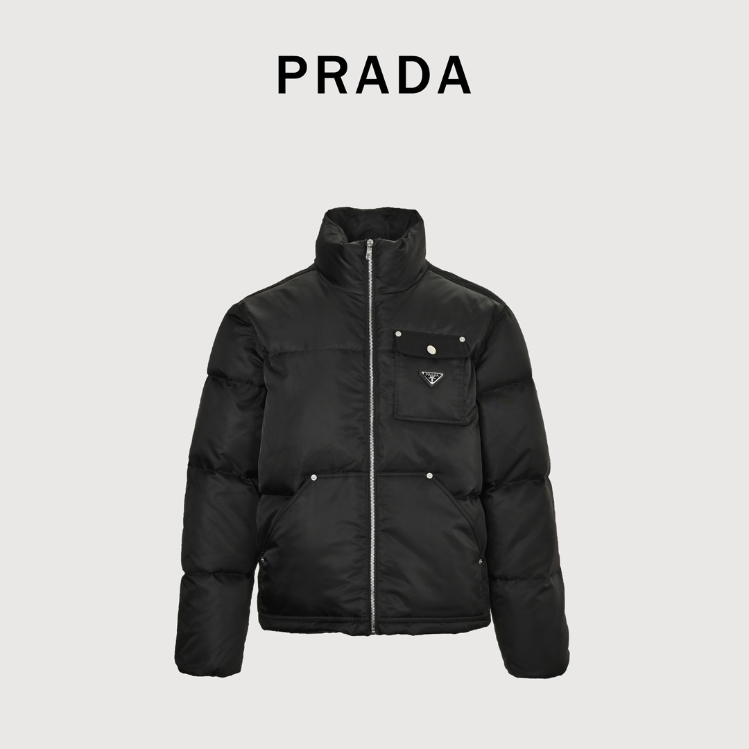 Locally picked 680 PRADA Prada PRD nylon logo flap pocket stand collar down jacket is made of environmentally friendly Re-Nylon material. The details are very exquisite, such as zippers, pockets, cuffs and other parts are carefully designed, using copper snap buttons and stainless steel triangle marks.High-quality stitching and advanced sewing equipment are used to ensure the durability and beauty of the jacket.At the same time, the filling of 90 white duck down has also been strictly screened and evenly distributed to ensure a good thermal insulation effect.Every detail is paid attention to during the production process, and everything from material selection to sewing process is strictly controlled to ensure quality and durability.Size：S-XL