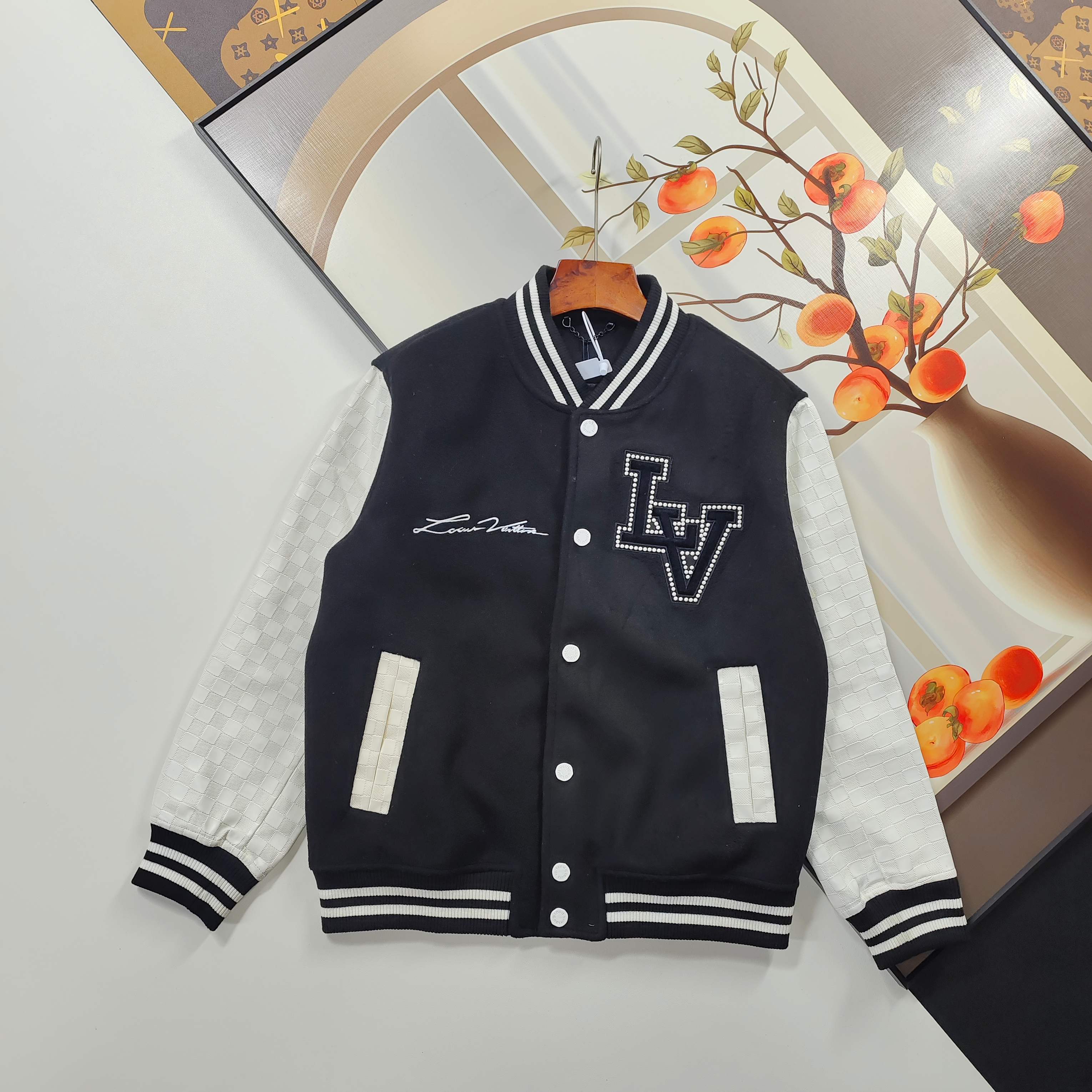 375 Size 46-52 Baseball Jacket 2025 Autumn and Winter Louis Vuitton Louis Vuitton Baseball Jacket Lujia LV Embroidered Baseball Tunic Jacket Baseball Tunic Jacket combines the American tradition of the spring and summer shows and the brand's exquisite craftsmanship. The Damier pattern is embossed on the cowhide leather sleeves, and the Louis Vuitton logo is expressed with beaded embroidery on the back.The crystal-embroidered PA patch on the chest recalls Pharrell Williams' youth as a member of the drum corps at Princess Anne High School in Virginia.Same style for men and women, high version